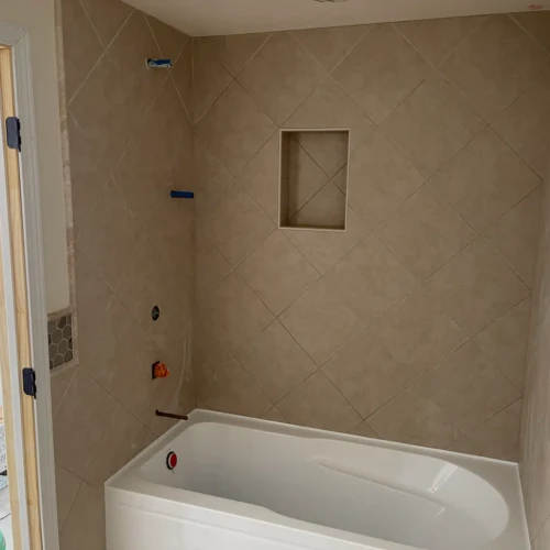 In-progress bathroom remodel featuring a bathtub surround with beige diagonal wall tile and a recessed niche in The Broadmoor, CO, by XCEL TILE.