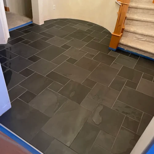 Custom curved entryway floor tile installation featuring dark multi-sized slate tiles in a 5-piece French Versailles pattern in Monument, CO, by XCEL TILE.