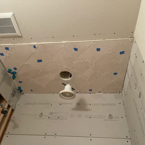 Shower ceiling under construction in Colorado Springs, CO, featuring light stone-look tiles installed in a diagonal pattern by XCEL TILE.