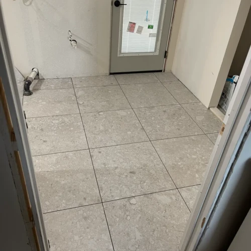 Residential bathroom featuring large-format light grey terrazzo-look porcelain floor tiles in Woodland Park, CO, by XCEL TILE.