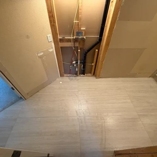 Bathroom subfloor undergoing large-format beige travertine-look porcelain tile flooring installation in Monument, CO, by XCEL TILE.