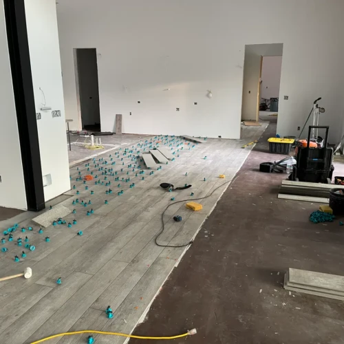 Open-concept living space in Black Forest, CO, undergoing extensive wood-look tile flooring installation using green leveling clips by XCEL TILE.