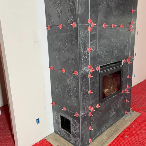 Close-up of a modern black fireplace surround tile installation by XCEL TILE in Parker, CO.