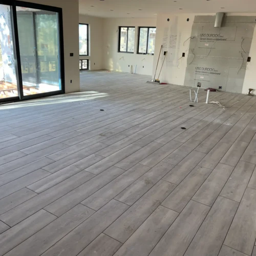 Wood-look residential floor tile installed in Parker, CO, in a large, open-concept living space by XCEL TILE.