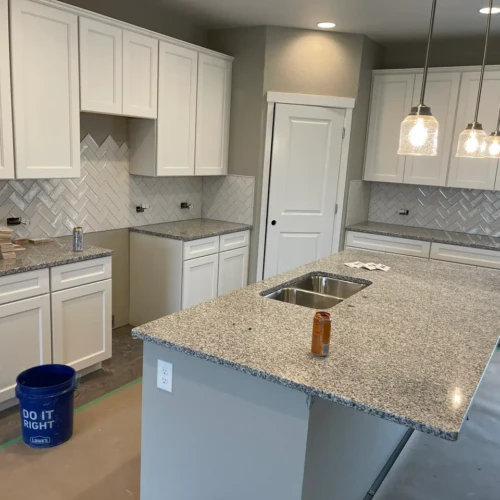 Modern kitchen featuring white ceramic subway tiles installed in a dynamic herringbone pattern in Colorado Springs, CO, by XCEL TILE.