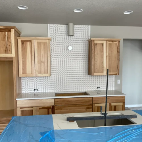 Custom kitchen range hood accent featuring small white hexagon mosaic tile in Colorado Springs, CO, by XCEL TILE.